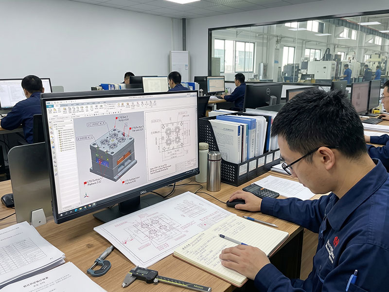 Engineers reviewing 3D CAD models and 2D prints