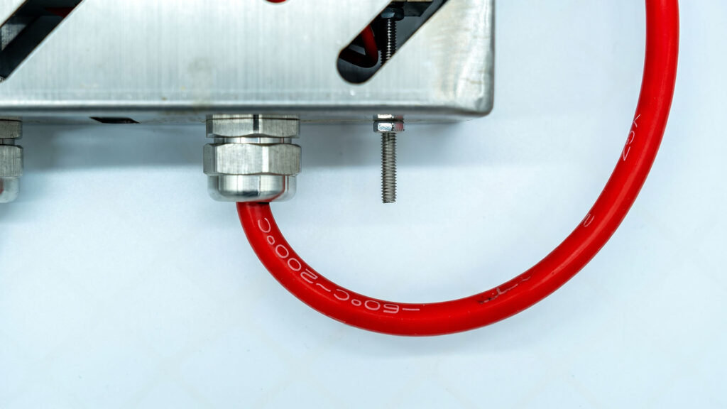 Close-up of metallic waterproof cable gland on metal enclosur