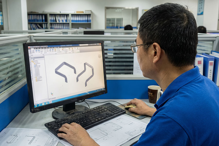 Engineer evaluating sheet metal CAD model for manufacturability