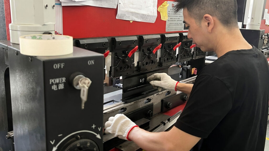 Operatore impegnato in un'operazione di piegatura di precisione su una pressa piegatrice ShincoFab