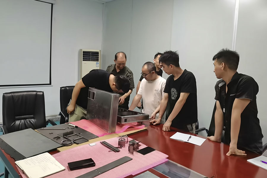 Quality control team reviewing a complex sheet metal assembly