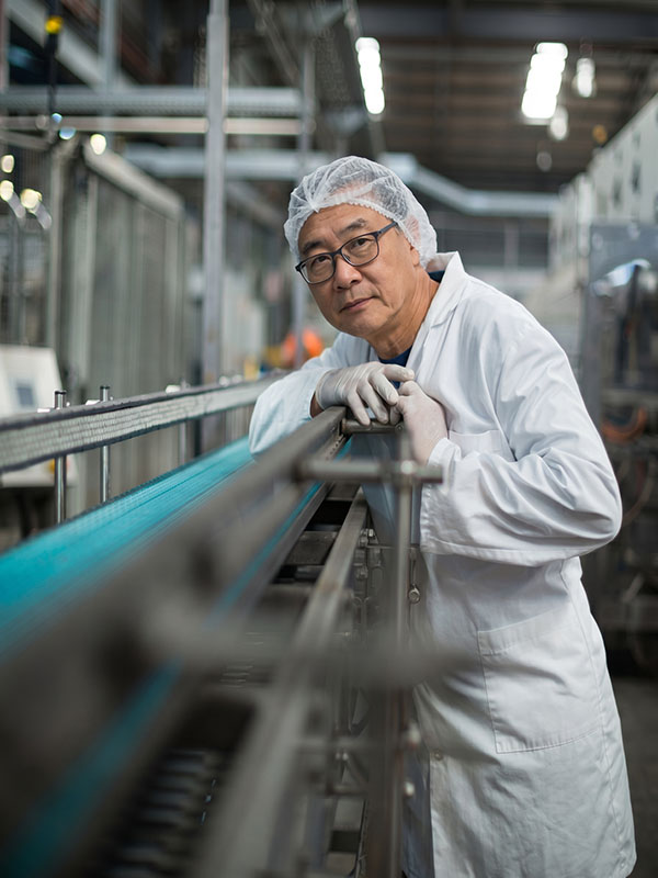 Quality engineer inspecting coated metal on a production line