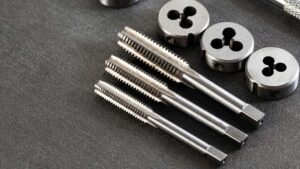 Three threading taps and three dies cleanly arranged