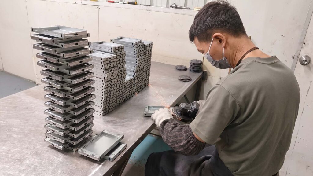 Worker grinding metal edges with angle grinder