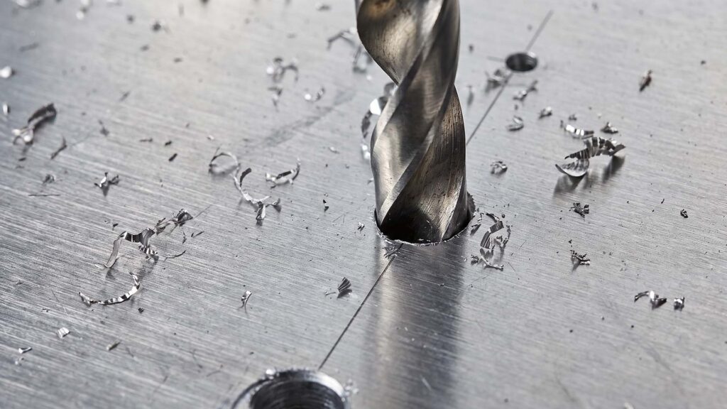 Close-up of drill bit cutting sheet metal