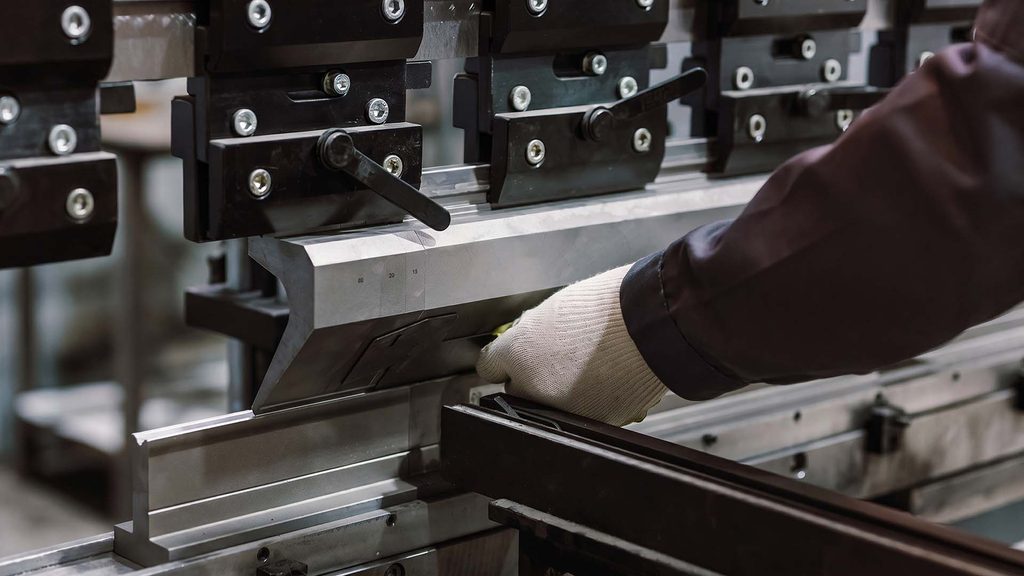 Gloved hands safely handling sheet metal part