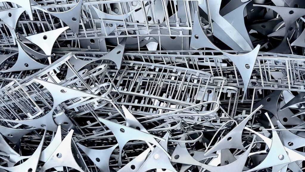 Laser-cut metal skeleton showing sheet nesting waste