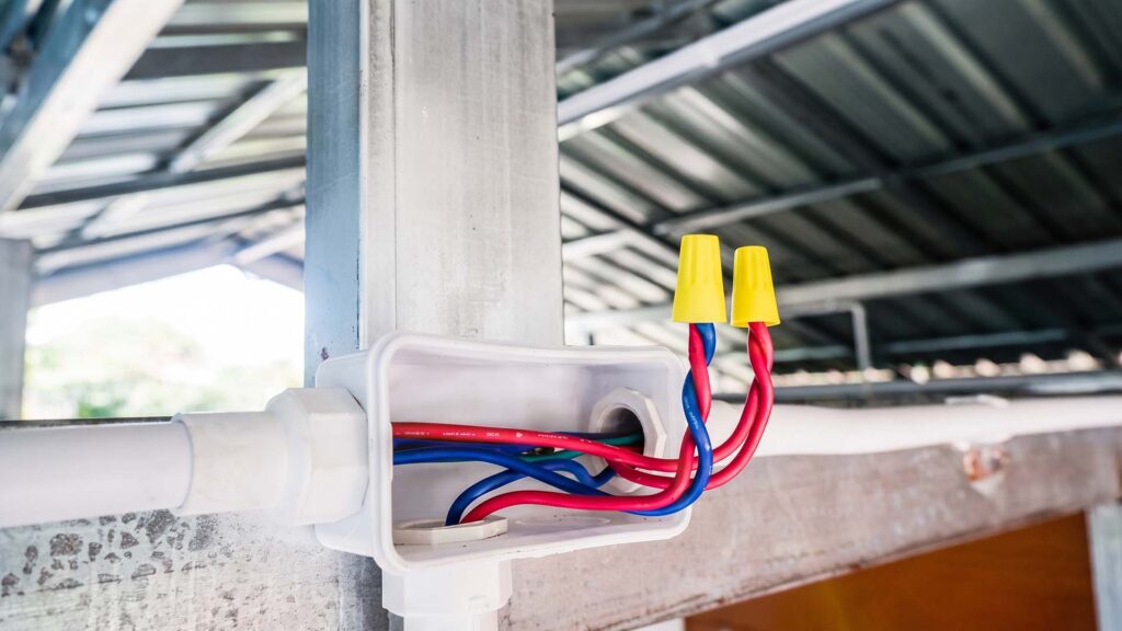 Open electrical junction box with yellow wire nuts
