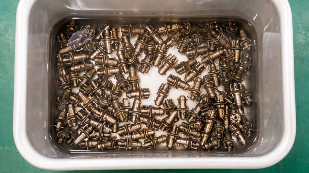 Stainless steel parts submerged in passivation bath