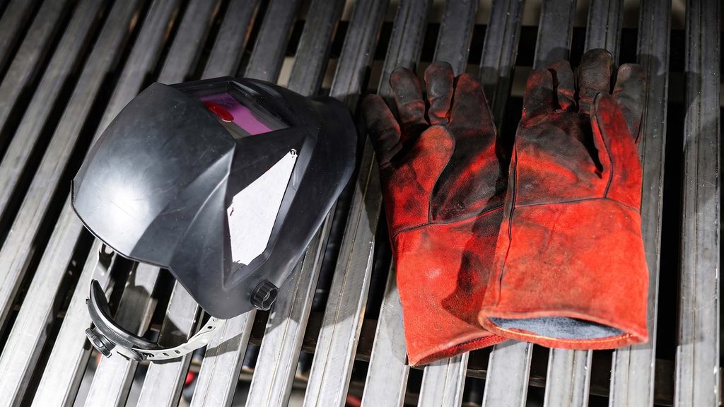 Welding helmet and safety gloves on table