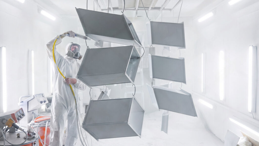 Worker powder coating fabricated sheet metal enclosures